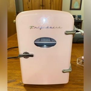 Light pink vintage style miniature Frigidaire cosmetics or soda fridge.